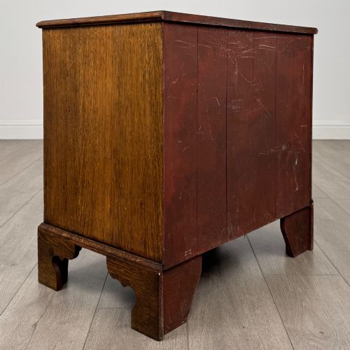 fig 3. An antique oak chest of drawers featuring two short over three long drawers with brass swan-neck handles and shaped bracket feet.