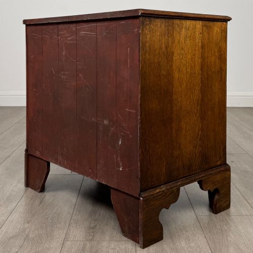 fig 5. An antique oak chest of drawers featuring two short over three long drawers with brass swan-neck handles and shaped bracket feet.