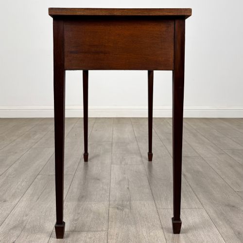 fig 2. An early 20th-century mahogany writing table featuring three drawers with decorative brass ring handles and square tapered legs.