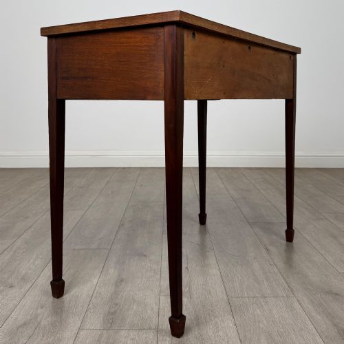 fig 3. An early 20th-century mahogany writing table featuring three drawers with decorative brass ring handles and square tapered legs.