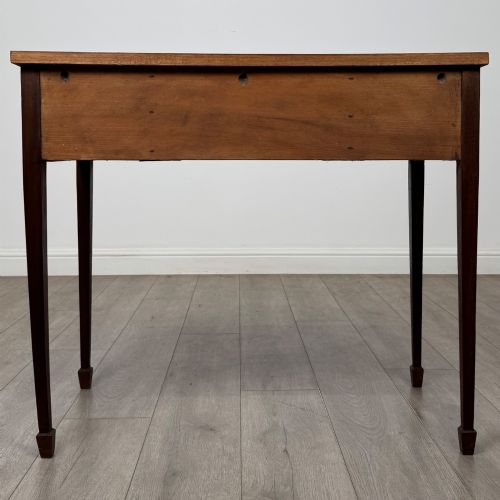 fig 4. An early 20th-century mahogany writing table featuring three drawers with decorative brass ring handles and square tapered legs.