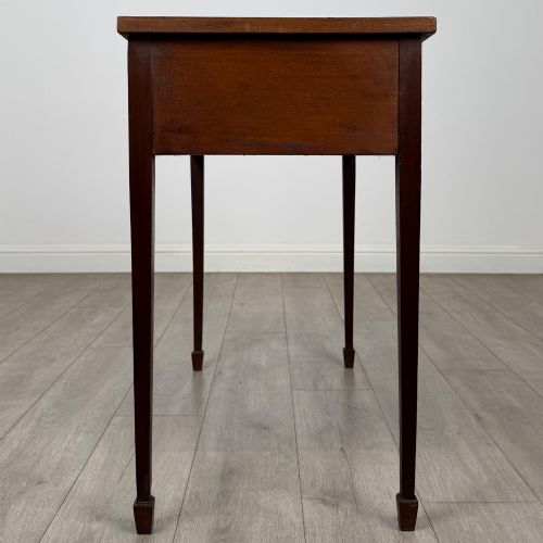 fig 6. An early 20th-century mahogany writing table featuring three drawers with decorative brass ring handles and square tapered legs.