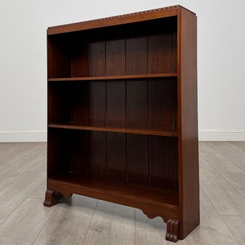 fig 2. An antique narrow mahogany open bookcase featuring three tiers, a gadrooned top edge, and carved bracket feet.
