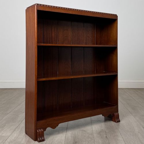 fig 8. An antique narrow mahogany open bookcase featuring three tiers, a gadrooned top edge, and carved bracket feet.