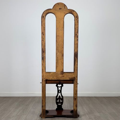 fig 4. A freestanding Victorian mahogany hall stand featuring turned coat pegs, a narrow central mirror panel, a small shelf, and an umbrella holder base.