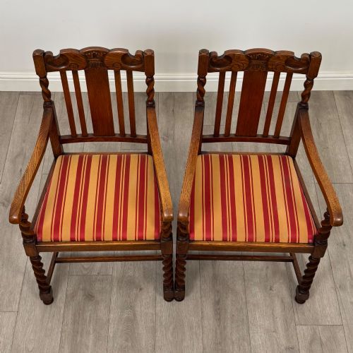 fig 8. A set of six dark oak dining chairs featuring barley twist legs and stretchers with red and gold striped fabric seats.
