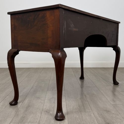 fig 3. An Edwardian mahogany writing table with cabriole legs, carved knee detailing, three drawers with ornate brass handles, and a central arched kneehole.