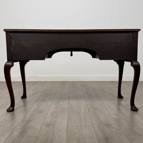 fig 4. An Edwardian mahogany writing table with cabriole legs, carved knee detailing, three drawers with ornate brass handles, and a central arched kneehole.