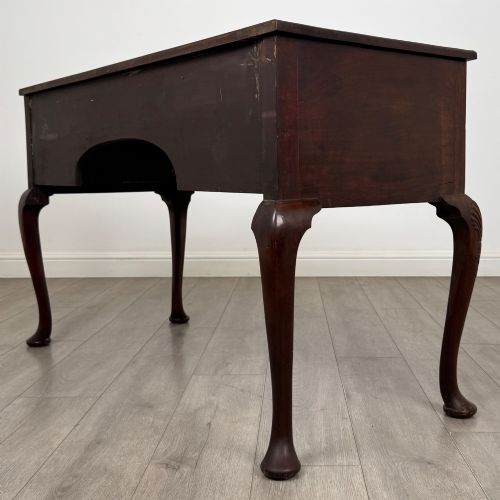 fig 5. An Edwardian mahogany writing table with cabriole legs, carved knee detailing, three drawers with ornate brass handles, and a central arched kneehole.