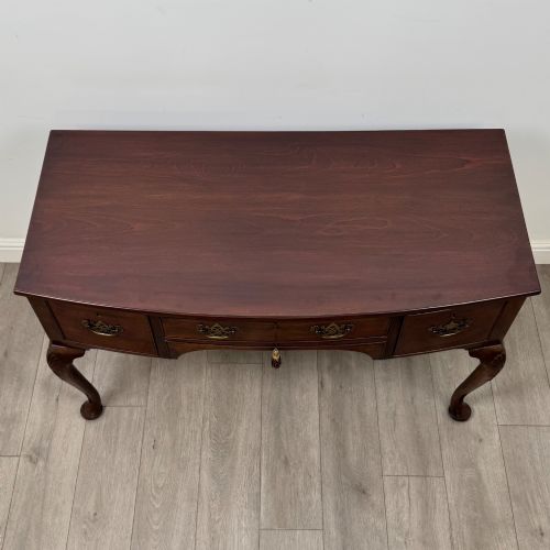 fig 8. An Edwardian mahogany writing table with cabriole legs, carved knee detailing, three drawers with ornate brass handles, and a central arched kneehole.