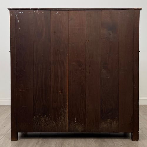 fig 5. A dark carved oak court cupboard featuring two top doors with relief carving, bulbous turned supports, two drawers, and two panelled cupboard doors below.
