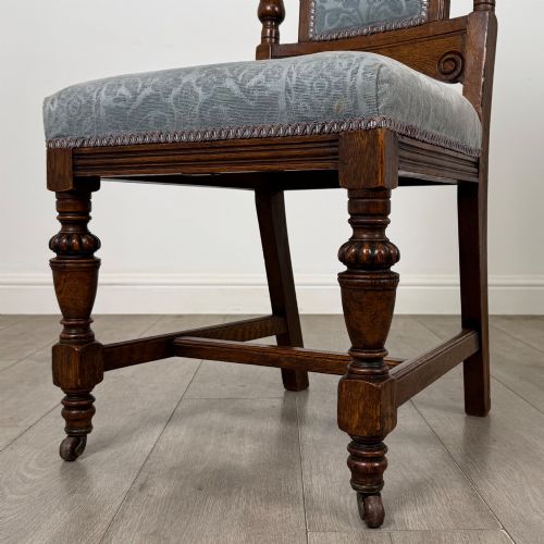 fig 4. A set of four 19th-century Victorian dark oak dining chairs featuring carved crest rails, turned legs, and light blue patterned fabric upholstery on the seats and backrests.