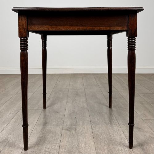 fig 2. An antique Edwardian dark oak side table featuring slender turned legs with ring details and a smooth square top surface.