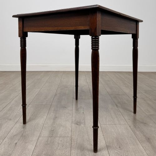 fig 3. An antique Edwardian dark oak side table featuring slender turned legs with ring details and a smooth square top surface.