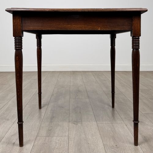 fig 4. An antique Edwardian dark oak side table featuring slender turned legs with ring details and a smooth square top surface.