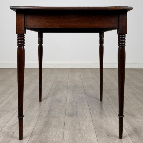 fig 6. An antique Edwardian dark oak side table featuring slender turned legs with ring details and a smooth square top surface.