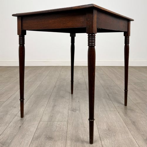 fig 7. An antique Edwardian dark oak side table featuring slender turned legs with ring details and a smooth square top surface.