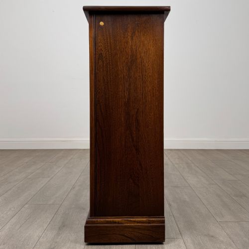 fig 3. A small vintage dark oak bookcase featuring three open shelves, decorative carved detailing along the frieze and side uprights, and a solid plinth base.