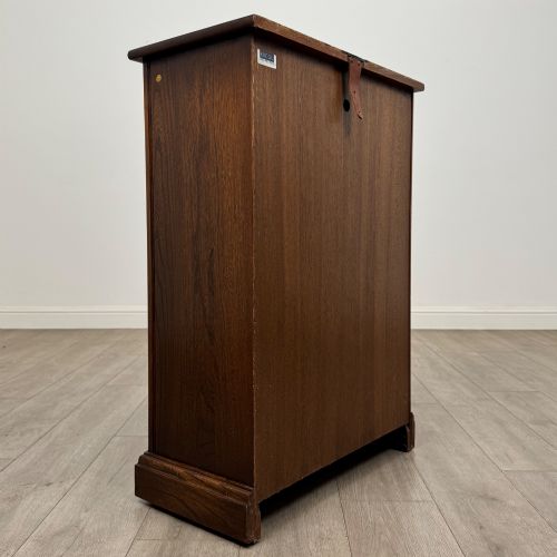 fig 4. A small vintage dark oak bookcase featuring three open shelves, decorative carved detailing along the frieze and side uprights, and a solid plinth base.