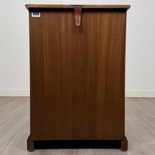 fig 5. A small vintage dark oak bookcase featuring three open shelves, decorative carved detailing along the frieze and side uprights, and a solid plinth base.