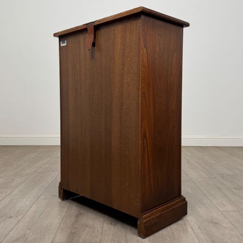 fig 6. A small vintage dark oak bookcase featuring three open shelves, decorative carved detailing along the frieze and side uprights, and a solid plinth base.