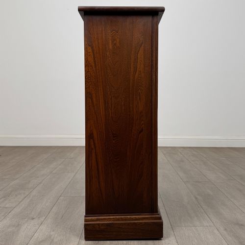 fig 7. A small vintage dark oak bookcase featuring three open shelves, decorative carved detailing along the frieze and side uprights, and a solid plinth base.