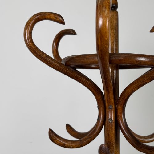 fig 4. A freestanding bentwood beech coat stand featuring curved upper hooks, a central umbrella ring, and splayed feet.