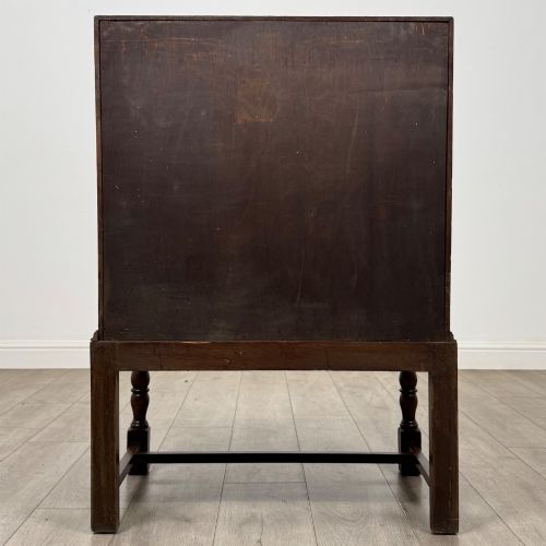 fig 5. An Edwardian dark oak writing bureau featuring a sloped drop-down lid, two lower drawers with teardrop handles, and turned legs connected by stretchers.