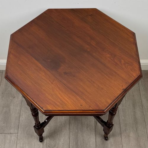 fig 5. An antique mahogany side table featuring an octagonal top, turned legs with castors, and a lower octagonal tier shelf.