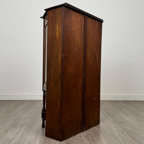 fig 4. An antique walnut display cabinet featuring glazed door and side panels, decorative inlay along the frieze, and an open lower shelf resting on turned front legs.
