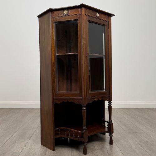 fig 8. An antique walnut display cabinet featuring glazed door and side panels, decorative inlay along the frieze, and an open lower shelf resting on turned front legs.