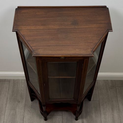 fig 9. An antique walnut display cabinet featuring glazed door and side panels, decorative inlay along the frieze, and an open lower shelf resting on turned front legs.