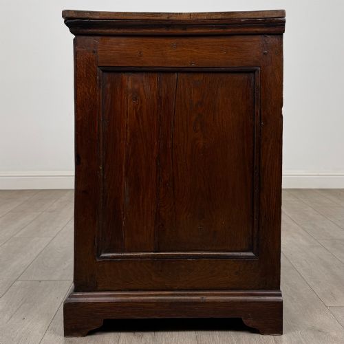 fig 2. An 18th-century dark oak Georgian chest of drawers featuring four graduated drawers with brass handles and keyhole escutcheons.