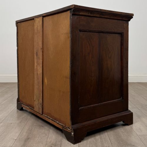 fig 5. An 18th-century dark oak Georgian chest of drawers featuring four graduated drawers with brass handles and keyhole escutcheons.