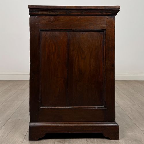 fig 6. An 18th-century dark oak Georgian chest of drawers featuring four graduated drawers with brass handles and keyhole escutcheons.