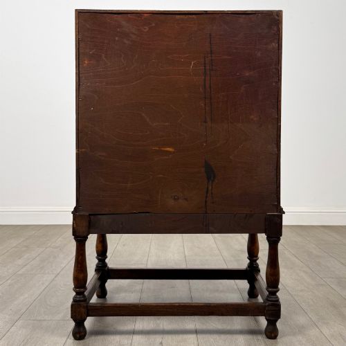 fig 5. An Edwardian golden oak writing bureau featuring a slant-front writing flap above two drawers with brass teardrop handles, supported on turned legs with a perimeter stretcher.