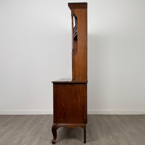 fig 3. A 20th-century golden oak Welsh dresser featuring a three-tiered open shelf top section over a two-door, two-drawer base with cabriole legs.