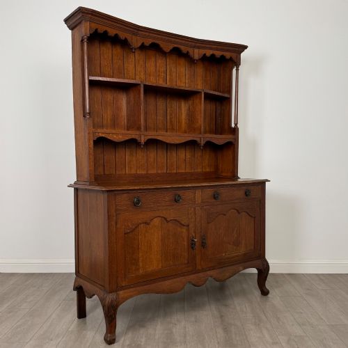 fig 8. A 20th-century golden oak Welsh dresser featuring a three-tiered open shelf top section over a two-door, two-drawer base with cabriole legs.