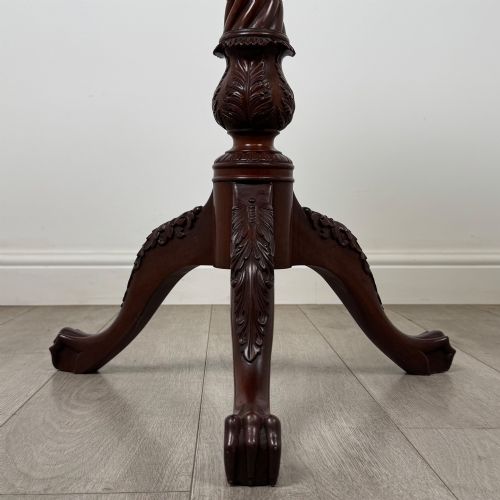 fig 4. A dark mahogany tripod occasional table featuring a piecrust scalloped top, a birdcage mechanism, a spiral turned column, and leaf-carved legs.