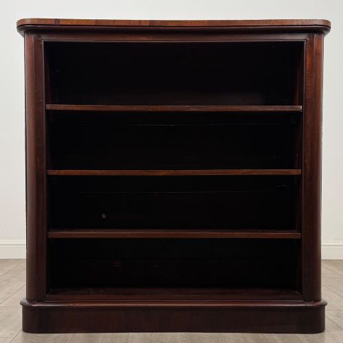 fig 1. An antique 19th-century Victorian mahogany open bookcase featuring four tier shelves, rounded front corners, and a solid plinth base.