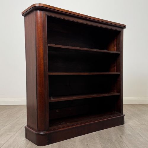 fig 8. An antique 19th-century Victorian mahogany open bookcase featuring four tier shelves, rounded front corners, and a solid plinth base.