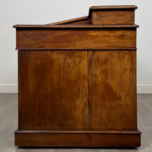 fig 2. A 19th-century Victorian mahogany Dickens desk featuring a sloped green leather writing top, a raised rear superstructure, and twin pedestals fitted with turned knobs.