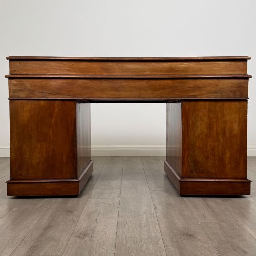 fig 4. A 19th-century Victorian mahogany Dickens desk featuring a sloped green leather writing top, a raised rear superstructure, and twin pedestals fitted with turned knobs.