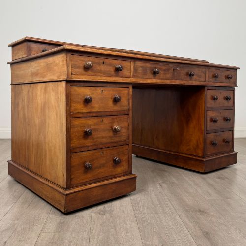 fig 7. A 19th-century Victorian mahogany Dickens desk featuring a sloped green leather writing top, a raised rear superstructure, and twin pedestals fitted with turned knobs.