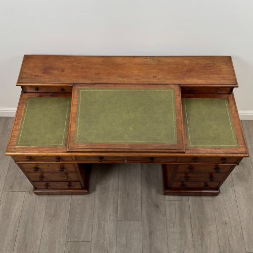 fig 8. A 19th-century Victorian mahogany Dickens desk featuring a sloped green leather writing top, a raised rear superstructure, and twin pedestals fitted with turned knobs.