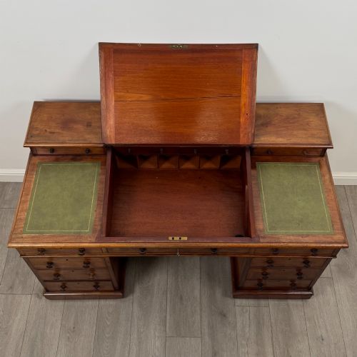 fig 9. A 19th-century Victorian mahogany Dickens desk featuring a sloped green leather writing top, a raised rear superstructure, and twin pedestals fitted with turned knobs.