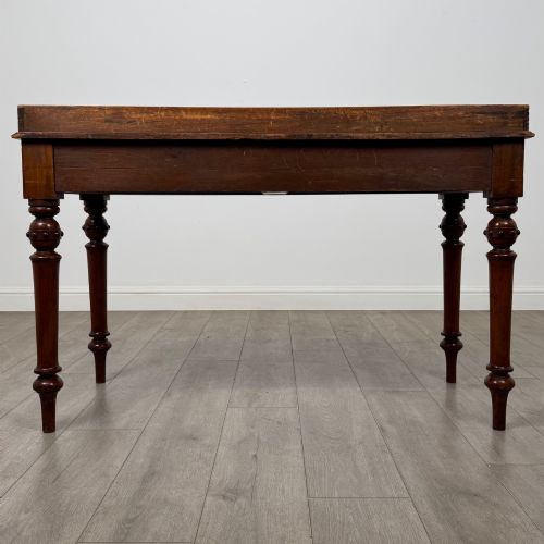 fig 4. A 19th-century mahogany writing table featuring two frieze drawers with wooden turned handles, standing on four turned legs.