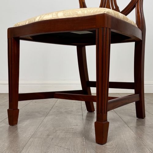 fig 4. A set of eight mahogany shield back dining chairs featuring intricate pierced back splats and light cream upholstered seats.