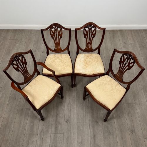 fig 6. A set of eight mahogany shield back dining chairs featuring intricate pierced back splats and light cream upholstered seats.