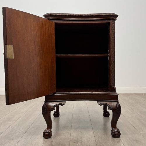 fig 1. A dark mahogany Chippendale style cupboard featuring a single door with an oval flame mahogany panel, carved borders, and cabriole legs with ball-and-claw feet.